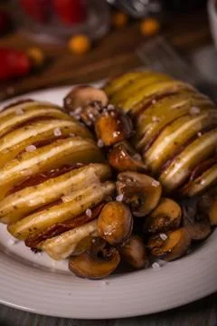 Two roasted filled potatoes with fried mushrooms Stock Photos