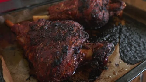 Two roasted mutton lamb leg covered with baking paper on baking tray. Vídeos de archivo 270431517