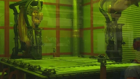 Two robotic arms are moving along the metal structure and welding the steel Stock Footage 202049545