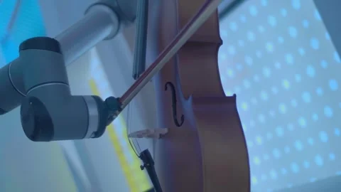 Two robotic hands skillfully play a melody on the cello Stock Footage 323942774