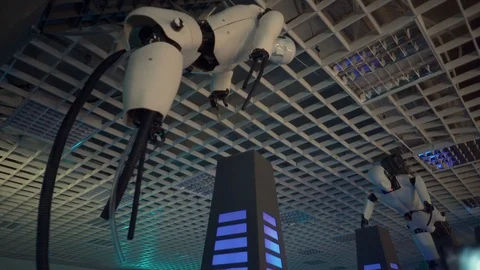 Two robots without legs fixed on the ceiling. Both robots rotate their heads fro 스톡 동영상 98823622