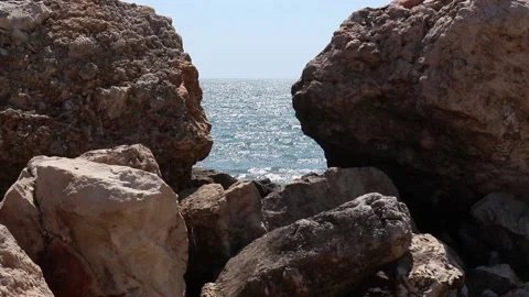 Two rocks form a natural window through which you can see the blue sea. Stock Footage 149819875