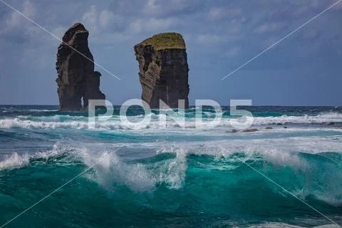 Two rocks in ocean water in rough sea waves Stock Photos