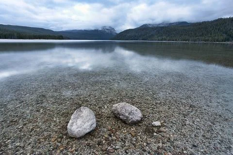 Two rocks in the shallow lake. Stock Photos