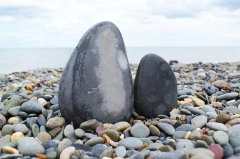 Two rocks on a stony beach. Smooth pebbles. Stock Photos