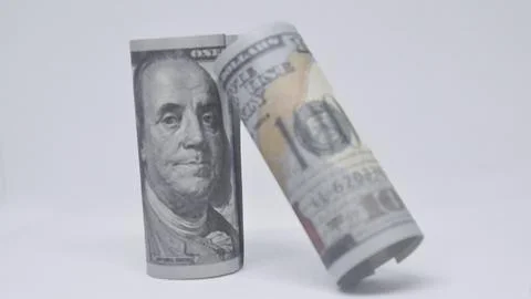 Two rolled dollar bills positioned on a white background, symbolizing savin.. Stock Photos