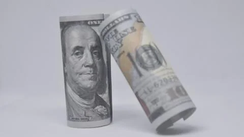 Two rolled dollar bills standing and leaning, symbolizing wealth, savings, .. Stock Photos
