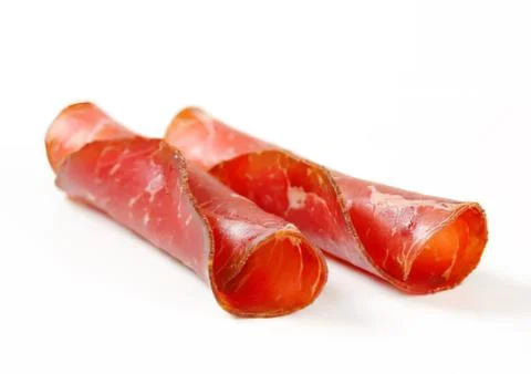 Two rolled slices of dried beef jerky Stock Photos