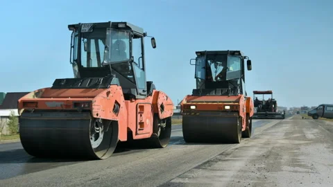 Two rollers level and compact the asphalt against the blue sky. Road rollers Stock-Footage 140102326