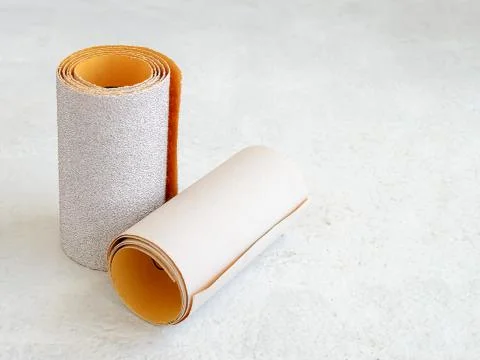 Two rolls of extra coarse and super fine aluminum oxide sandpaper on a white Stock Photos