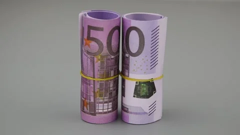 Two rolls of rolled 500 euro banknotes are blown away by a gust of air. Close-up Vídeo Stock 141644992