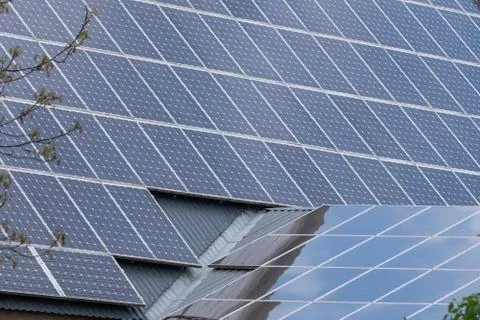 Two roofs with solar panel reflecting the clouds en trees. In the Netherlands Stock Photos