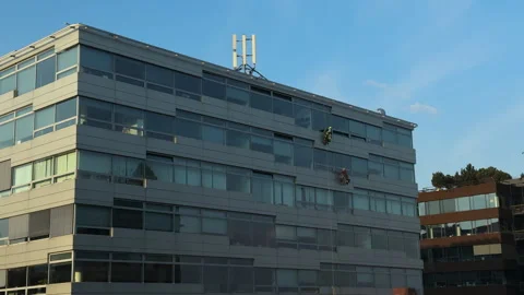Two Rope Access Technicians Abseiling on Glass Office Building Facade Stock Footage 331522548