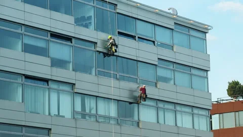 Two Rope Access Workers Cleaning Windows on High-Rise Office Building Facade 스톡 동영상 331523120