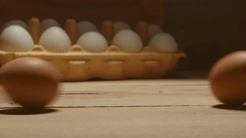 Two rotating brown eggs hitting each other on wooden floor 動画素材 130884283