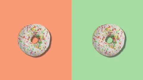 Two rotating donuts on orange and green screen divided into two parts. Stock Footage 123231627