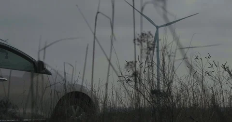 Two Rotating Wind Generator In Front Of A Car. . Wind Turbine Stock Footage 123712467