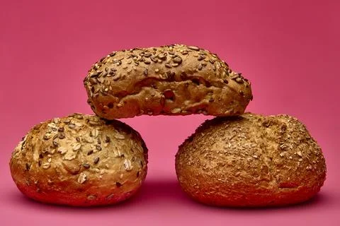 Two round buns with seeded bread on pink background Foto stock