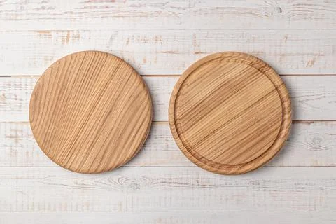 Two round cutting boards with edging on a white wooden table. mockup of a foo Photos