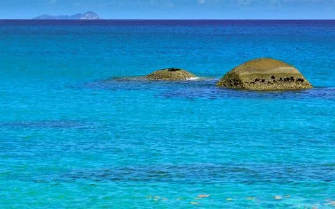 Two round rocks in the turquoise colored waters of the seychelles Stock Photos