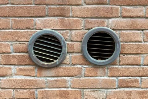 Two Round Vent Grilles in Brick Wall 写真素材