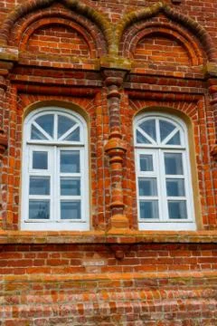 Two rounded windows on old red brick wall Stock Photos