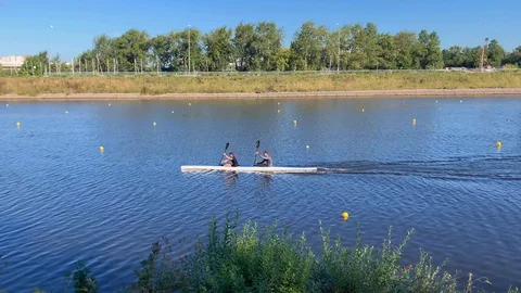 Two rowers on a boat sail the river Stock-Footage 115964374