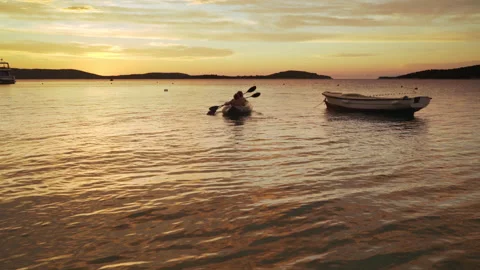 Two rowers on inflatable kayak rowing by the evening Adriatic sea harbor Croatia Video stock 231194999