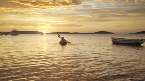 Two rowers rowing on inflatable kayak by the evening Adriatic sea harbor, Croati Stock-Footage 231335158
