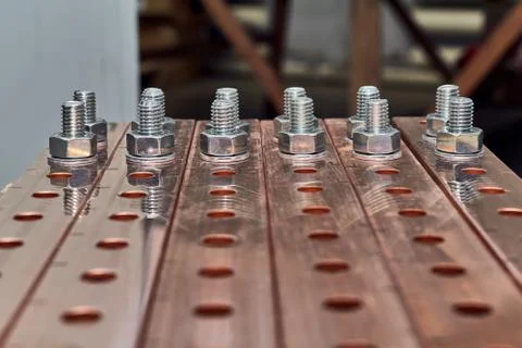 Two rows of bolts with washers and nuts fixed in busbars. Stock Photos