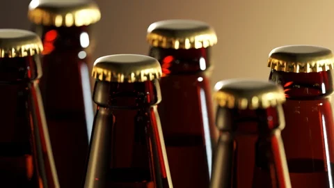 "Two rows of brown beer bottles in a closeup view. Endless, seamless loop. 4K Stock Footage