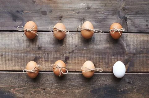 Two rows of eggs tied by threads on wooden background Stock Photos