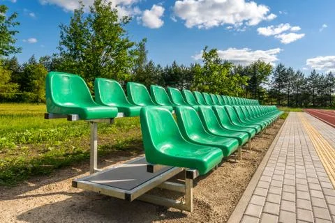 Two rows of green plastic seats on the stadium Stock Photos