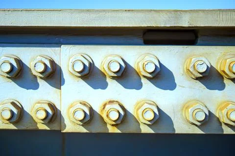 Two rows of large bolts and nuts, integral for securing bridge metal structur Stock Photos