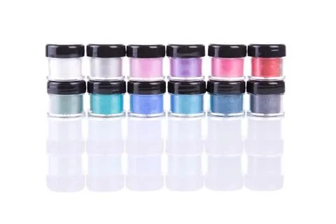 Two rows of loose eye shadows in plastic jars 스톡 사진