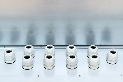 Two rows of modern stuffing box packing glands for sealing electrical cables. Stock Photos