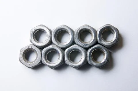 Two Rows of Screw Nuts on White Stock Photos