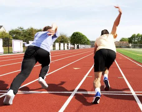 Two runners aggresively starting a sprint race on a track Stock Photos