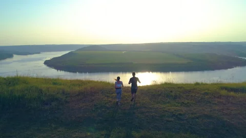The two runners jogging on the mountain top against the river. slow motion Stock Footage 160013794