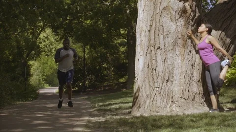 Two Runners Meet while Stretching in Park 1 Stock-Footage 91981701