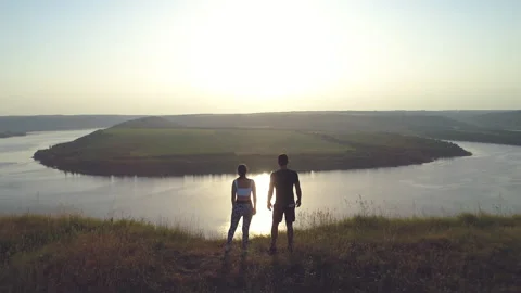 The two runners standing on the mountain top against the river. slow motion Video stock 160013525
