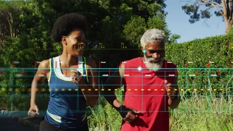 Two running partners jogging along park path, motion activating fitness HUD Stock Footage 333837717