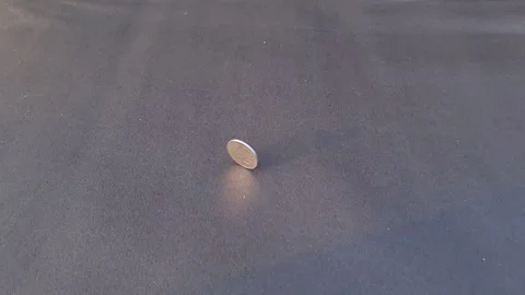 A Two Rupees Indian Coin Spinning On Black Paper in Slow Motion Stock Footage 267187584