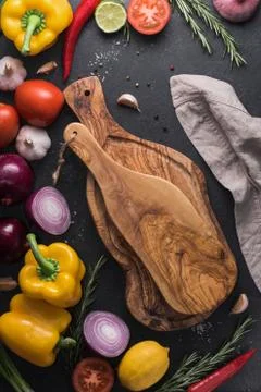 Two rustic cutting boards on the black kitchen table among fresh vegetables, Stock Photos