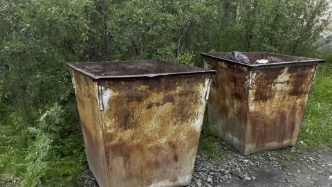 Two rusty metal dumpsters with heavy corrosion and weathering, positioned outdoo Stock Footage 339995829