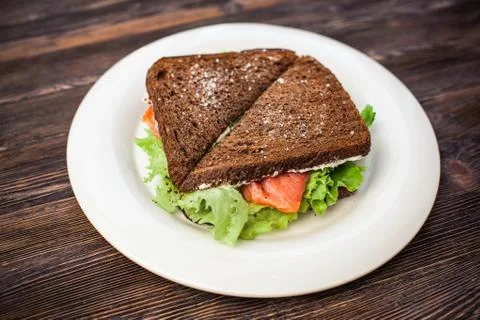 Two rye bread sandwiches with red fish and lettuce. Stock Photos