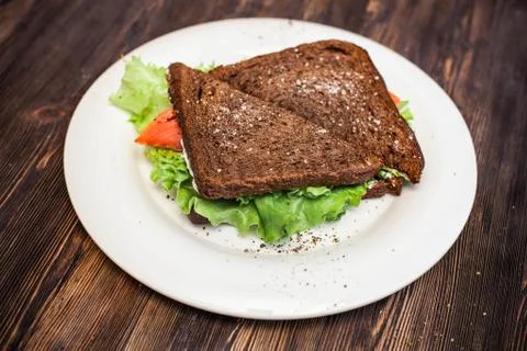 Two rye bread sandwiches with red fish and lettuce. Stock Photos