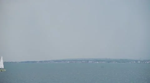 Two of a sailboat floating under a clear sky. Lake with blue water. Stock Footage 65331424