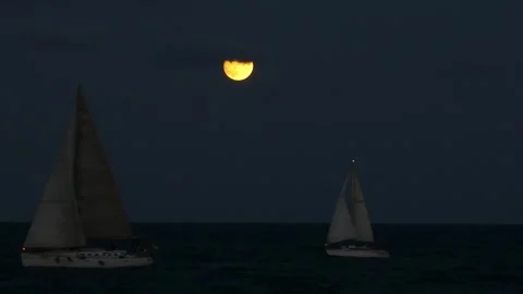 Two sailboats under full moon with passing cloud on summer night Stock Footage 319814336