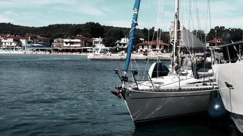 Two Sailing Boats are Gracefully Docked at a Beautifully Serene Waterfront Area Stock Footage 312522161